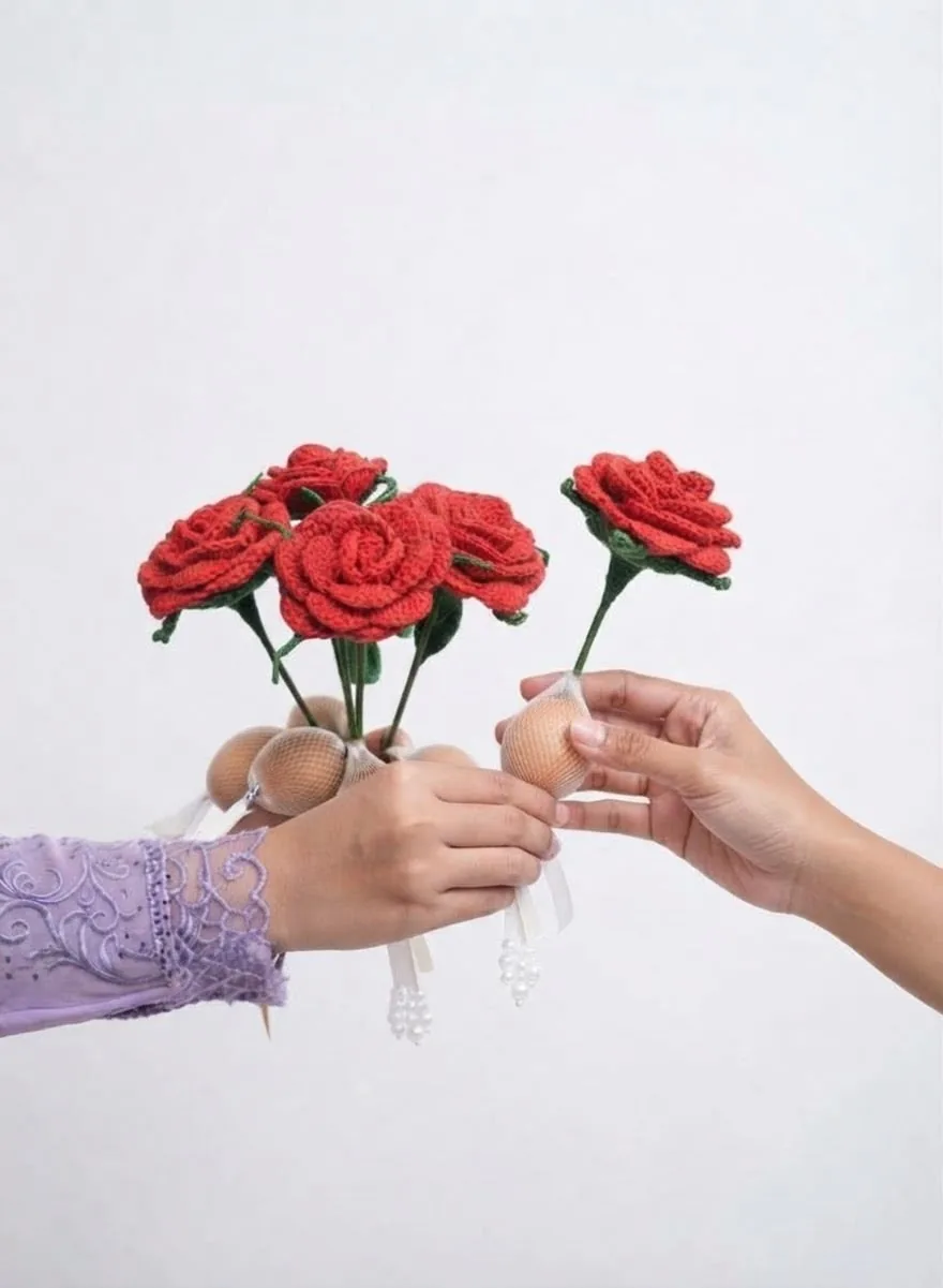 Dua tangan berkongsi setangkai ros crochet